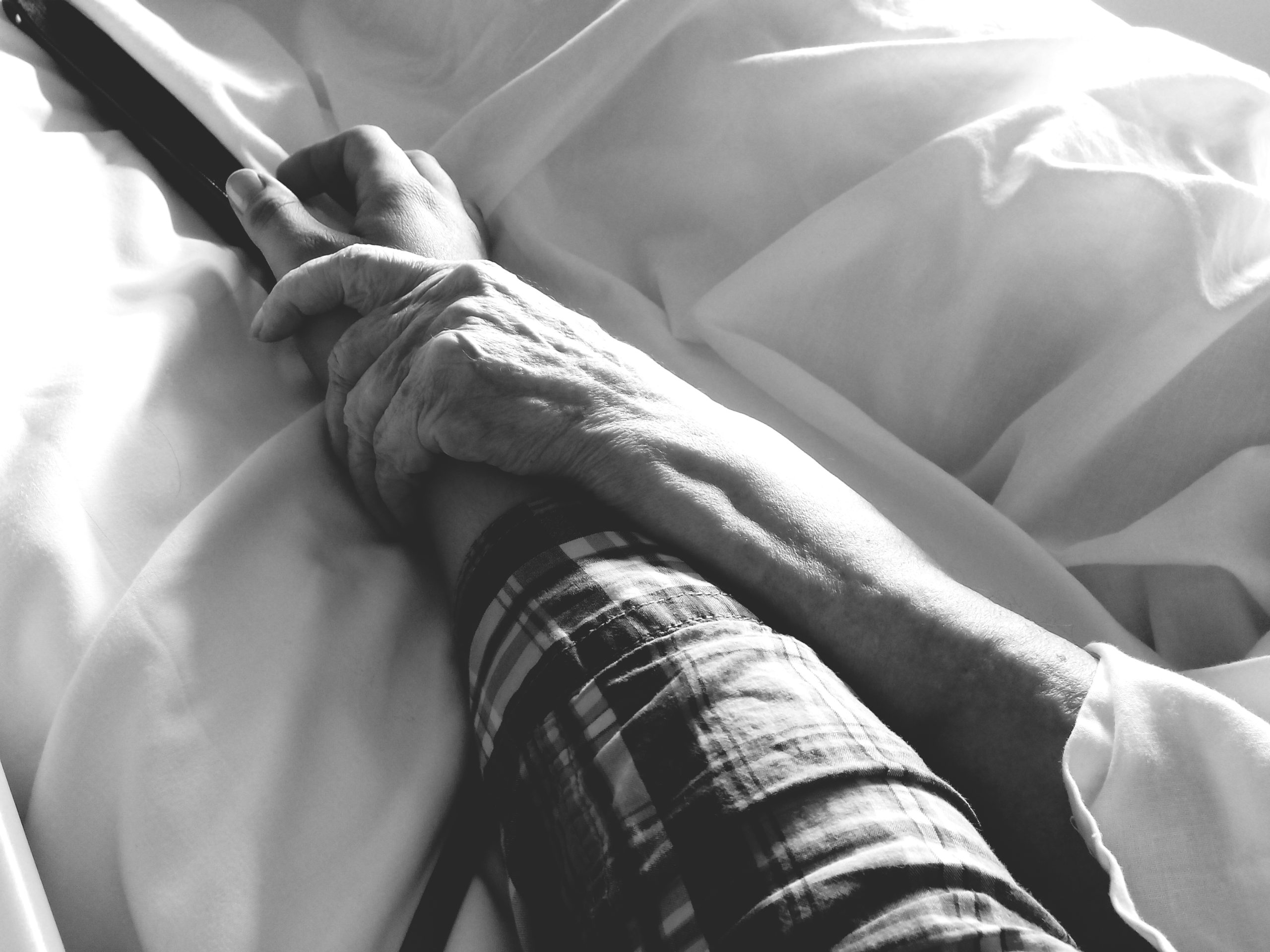 cropped-people-holding-hands-bed