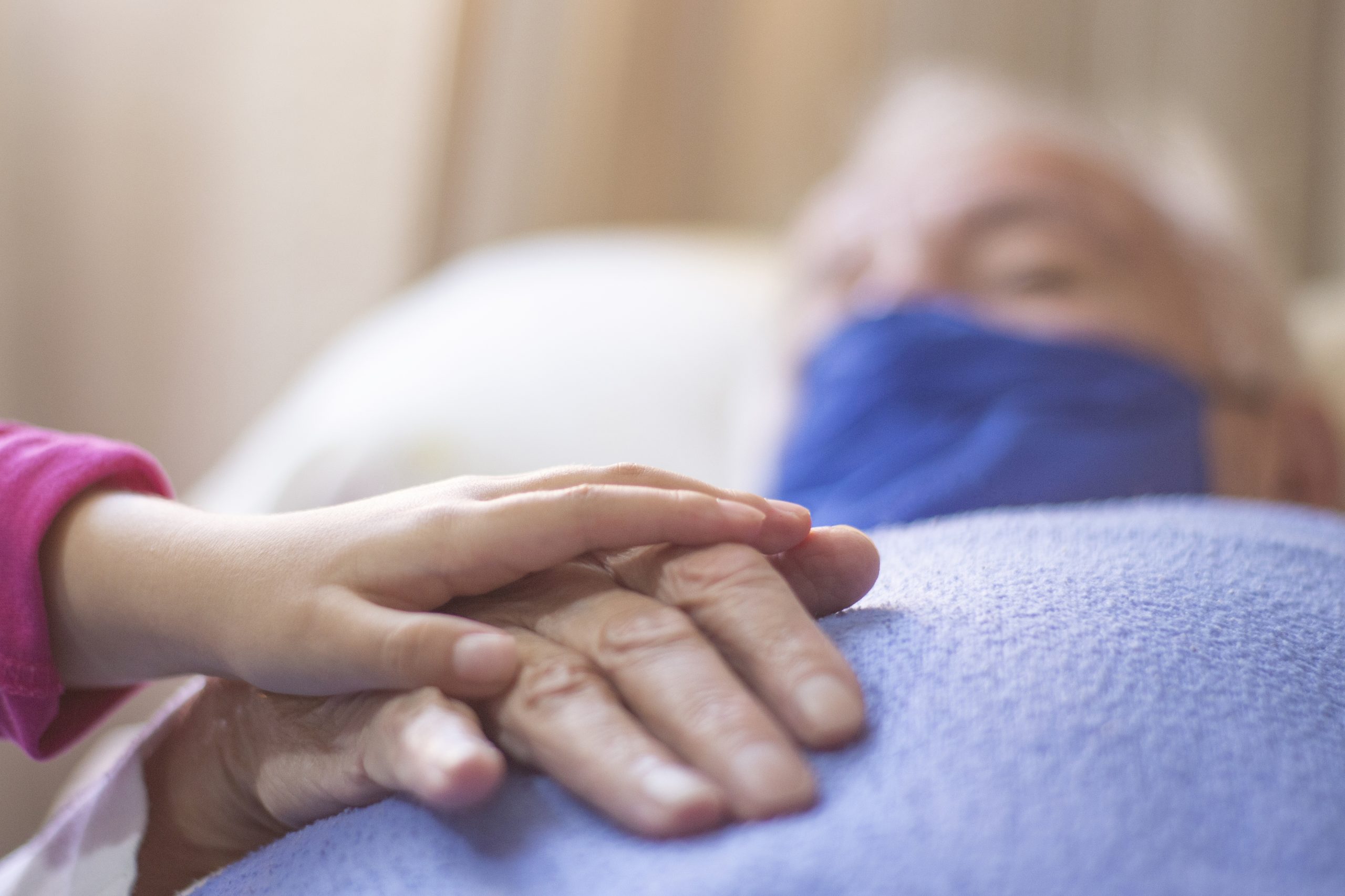 man-holding-child-s-hand-bed